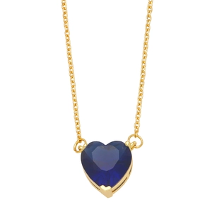 Macro detail of heart-shaped blue sapphire pendant with gold claw setting and fine chain