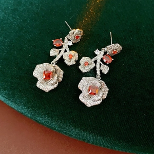 Macro shot of vintage silver flower earrings with red stones and clear crystals