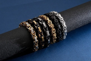 Close-up of Byzantine style box link bracelets in gold, silver, and black finishes