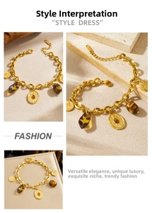 Detail of vintage gold plated Cuban chain bracelet with star charms and tiger eye stone