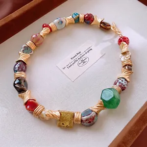 Vintage floral geometric ceramic beaded necklace with gold metal accents in a jewelry box