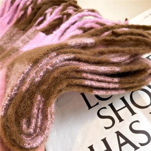 Macro shot of brown and pink cashmere-feel scarf showing soft texture and tassel detail
