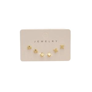 Three-piece gold geometric stud earring set including heart, cube, and X shapes on display card