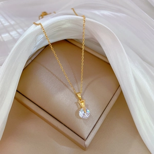 Detailed view of a gold V-shaped pendant with sparkling zircons on a silk background