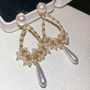 Detailed close-up of French vintage pearl tassel drop earrings with golden hollow frame