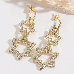 Detailed close-up of gold double star earrings with shimmering white zircon stones