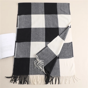 Close-up of black and white plaid scarf with soft fringe details and woven texture