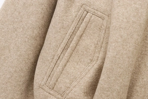 Dettaglio del bomber color cammello con cuciture delle tasche e trama del tessuto lana
