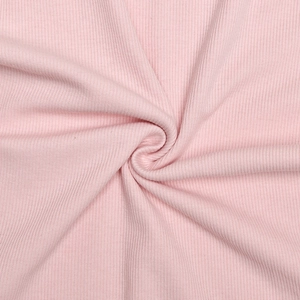 Gros plan sur un tissu en maille côtelée rose montrant texture et élasticité
