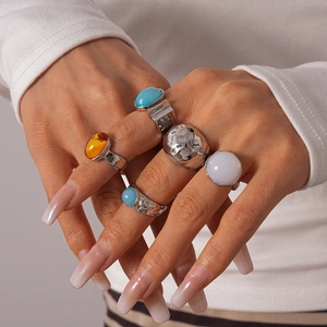 Ensemble de cinq bagues vintage en métal et résine avec pierres colorées sur main
