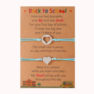 Dettaglio di due braccialetti intrecciati azzurri con cuore su una card per la scuola