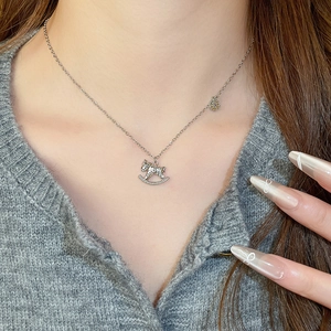 Vue détaillée du collier en argent avec pendentif cheval à bascule et zircons sur le cou