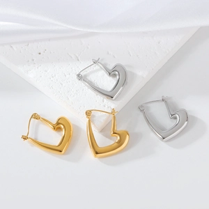 Détail des boucles d'oreilles cœur en forme de U, finitions or et argent sur pierre