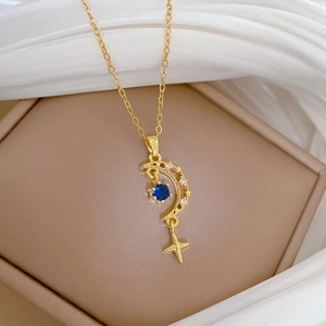 Detail of star and moon pendant necklace with blue gemstone and shimmering crystals
