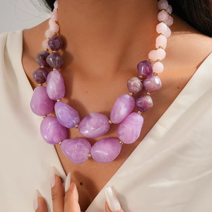 Detail of chunky pink and purple gradient acrylic beads on a layered sweater necklace
