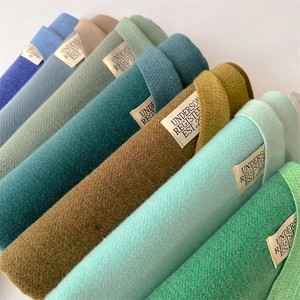 Close-up of neatly folded soft cashmere scarves in multiple colors with brand labels