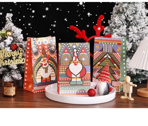 Detailed view of Christmas paper gift bags with Santa and tree motifs in festive settings