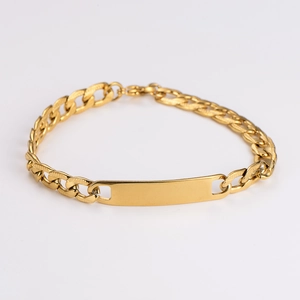 Close-up of golden Cuban link bracelet with a blank rectangular ID plate for custom engraving