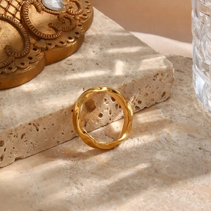 Macro view of gold plated stainless steel ring with elegant geometric water wave pattern