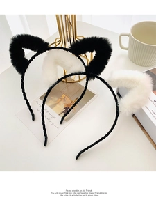 Gros plan de serre-têtes oreilles de chat en peluche noire et blanche texturés