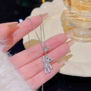 Macro view of silver bear pendant with crystals and star link on a delicate chain