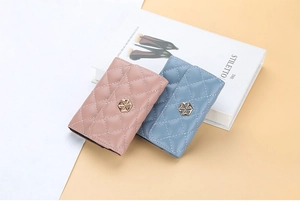 Close-up of pink and blue quilted PU leather card holders with gold geometric buckles