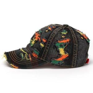 Detailed side view of distressed denim baseball cap with colorful frayed thread accents