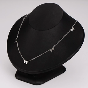Elegant silver stainless steel necklace with multiple bow pendants on a black neck model