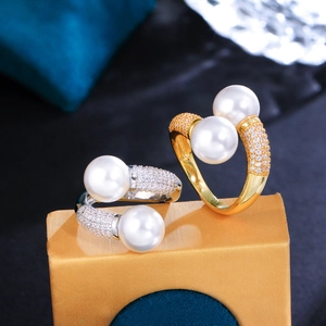 Vue macro de bagues doubles perles avec micro-pavage de zircons sur anneaux or et argent