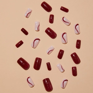 Deep red shimmer and blush pink press-on nails with heart patterns and wavy lines
