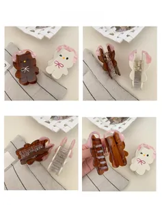 Detail view of acetate hair claws featuring cute bear with pink headphones and bow