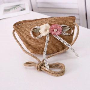 Detail of straw woven bag with floral accents and soft cotton rope shoulder strap