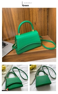 Detail of green crocodile texture handbag with woven handle and adjustable strap