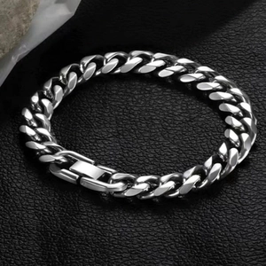 Close-up of polished silver titanium steel Cuban chain bracelet with secure clasp on leather