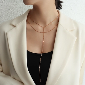 Elegant gold double layer tassel necklace in 18k plated titanium steel on female model