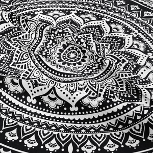 Gros plan sur le tissu d'une tapisserie mandala noire et blanche au style bohème chic