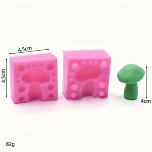 Pink silicone mushroom cake mold with green finished product on a clean white background