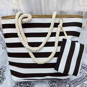 Detail of black and white striped canvas beach tote bag with beige rope handles