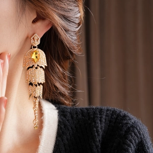 Detail of vintage gold tassel earrings with pearls and yellow teardrop gemstones