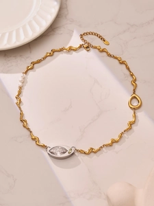 Detail of gold wavy chain necklace with marquise zircon pendant and white pearls