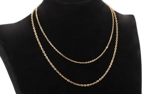 Detail of a thin double-layered gold O-chain necklace on a black velvet display stand