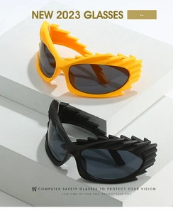 Detail of spiked irregular frame sunglasses in yellow and black on white stone pedestals
