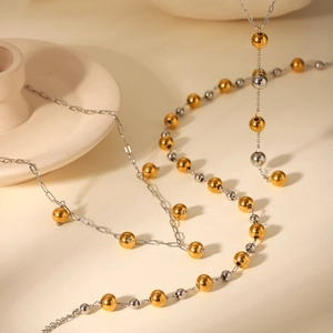 Detail of delicate two-tone gold and silver beaded necklace with fine steel chain link