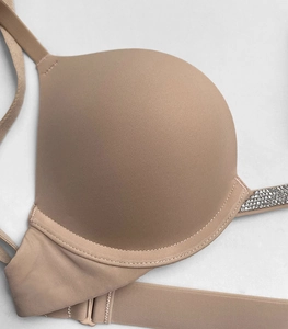 Close-up of beige push-up bra featuring shiny silver rhinestone embellished straps