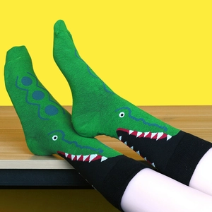 Dettaglio dei calzini in cotone con motivo a coccodrillo verde e divertente design a bocca aperta