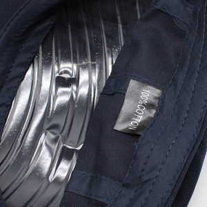 Close-up of internal 100% cotton label and reinforced stitching on a navy beret cap