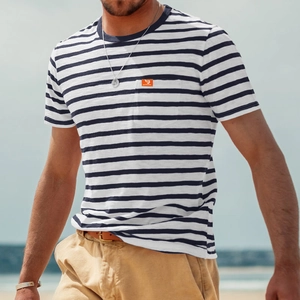 Detail of men's striped cotton t-shirt with chest pocket shown in a beach setting