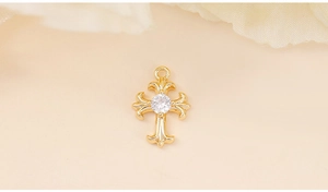 Macro shot of gold cross pendant featuring a central sparkling cubic zirconia stone