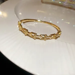 18k gold plated snake chain link bracelet with sparkling cubic zirconia on a white tray