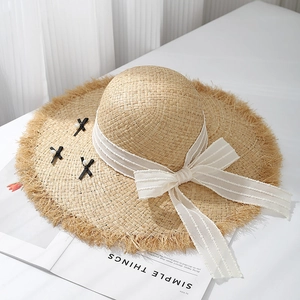 Chic raffia sun hat with frayed brim, lace ribbon, and black bow accents for women